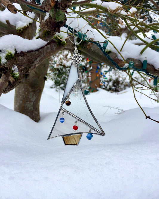 A stained glass christmas tree ornament in shades of white and clear